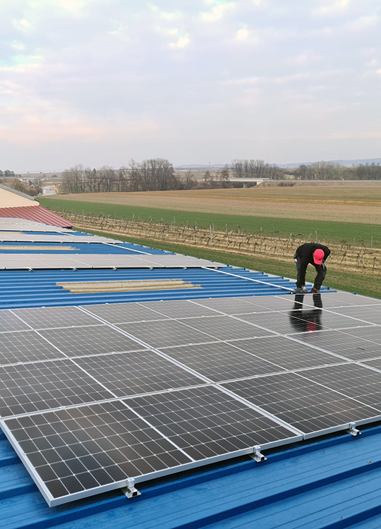 Worker inspecting solar panels on a rural roof